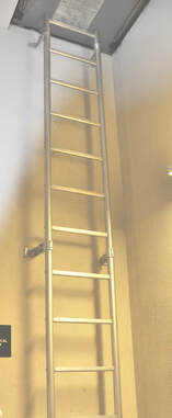 An aluminum fixed ladder that leads to an access hatch.