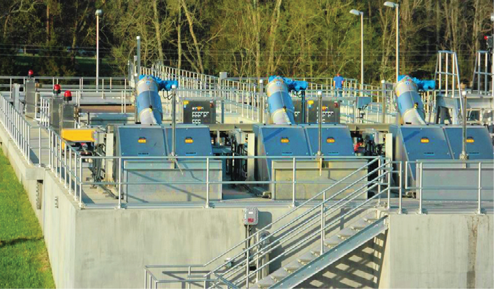 A sprawling water treatment plant with aluminum industrial handrails and stairs