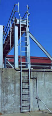 An aluminum industrial ladder the goes into a lowered area at a plant.
